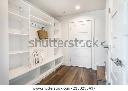 pantry and mudroom with white walls shelving hardwood floor Royalty-Free Stock Photo #2150235437