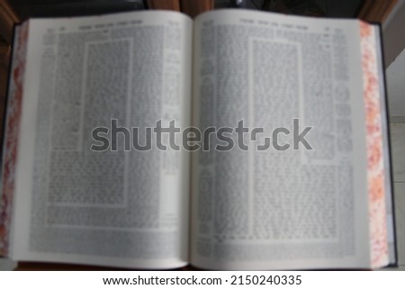 A Babylonian Talmud Talmud open on a blurry stand inspired image. Royalty-Free Stock Photo #2150240335