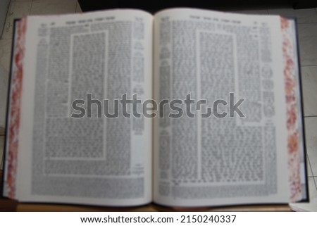 A Babylonian Talmud Talmud open on a blurry stand inspired image. Royalty-Free Stock Photo #2150240337
