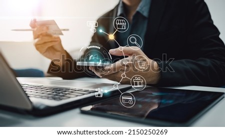Businessman with mobile smartphone and credit card in hand paying online shopping on virtual interface global network. Online banking transaction and digital marketing technology concept.