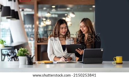 Two young Asian business woman talk, consult, discuss working with new startup project idea presentation analyze plan marketing and investment in the office. Royalty-Free Stock Photo #2150253841