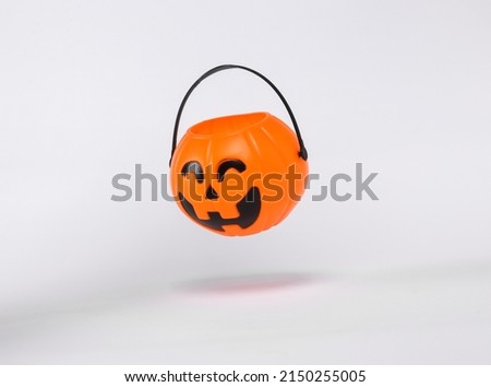 Floating Halloween jack pumpkin bucket on white background with shadow. Trick or Treat