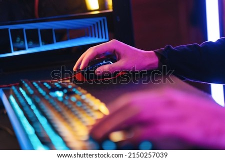 Male pro gamer's hands playing computer video game with professional computer mouse and keyboard. Close up of cyber sportsman hands on gaming equipment. Selective focus on hand. Cyber sport concept Royalty-Free Stock Photo #2150257039