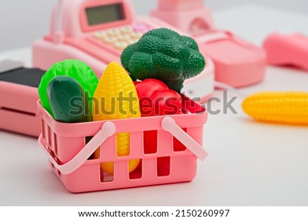 plastic children's toy vegetables in pink basket, children's games, food delivery concept, closeup Royalty-Free Stock Photo #2150260997