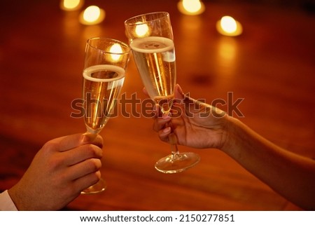 Heres to us. Shot of an unidentifiable couple toasting with champagne.
