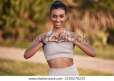 I love the way I look and feel. Portrait of a sporty young woman making a heart shape with her hands while exercising outdoors.