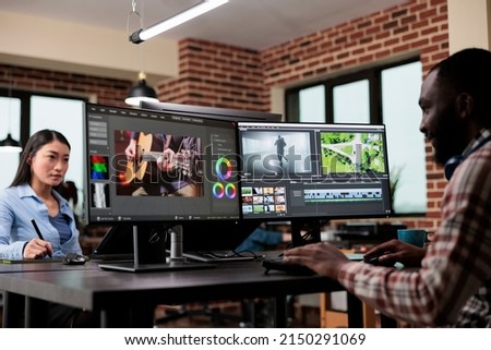 Post production department team leader editing movie footage using advanced technology software. Creative agency professional editor enhancing video film quality while sitting at desk.