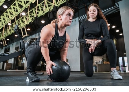 Midget woman training with hard ball under the supervising of her female trainer Royalty-Free Stock Photo #2150296503