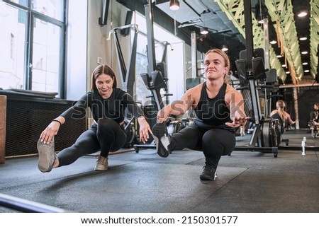 Midget woman sitting at the one leg and doing exercises with her female trainer Royalty-Free Stock Photo #2150301577