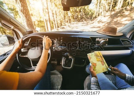 Multiracial senior women having fun on the road in camper van - Focus on hands holding book map Royalty-Free Stock Photo #2150321677