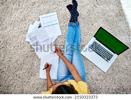 It was part of her homework to learn financial responsibility. High angle shot of an unrecognizable teenage girl doing schoolwork at home.