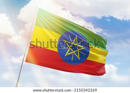Sunny blue sky and a flagpole with the flag of ethiopia