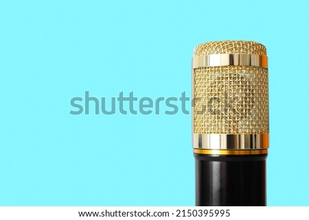 Modern microphone on blue background, closeup