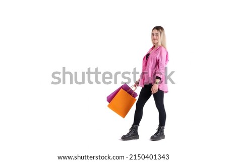Young woman standing posing with shopping bags in her hand looking at camera