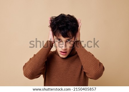 portrait of a young man brown turtleneck posing fashion light background unaltered