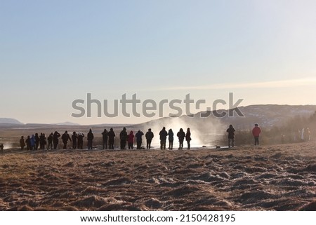 People and tourists watching the steam and waiting for the eruption of a geyser in Iceland ready to take natural pictures of the beautiful natural phenomenon with their cameras