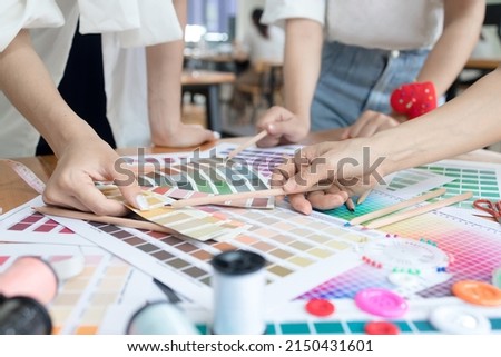 Young team asian designer women working at studio. Fashion designer carefully creating new fashionable styles. Dressmaker makes clothes job Royalty-Free Stock Photo #2150431601