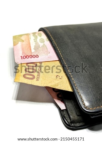 Money in black leather wallet isolated on white background