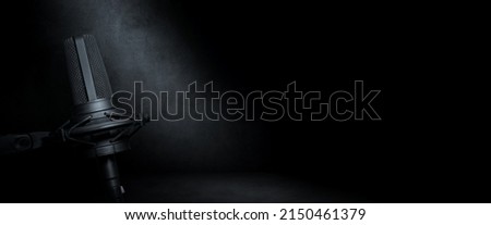 Vocal microphone on dark concrete background. Urban radio, music production or podcast banner with copy space for website header Royalty-Free Stock Photo #2150461379
