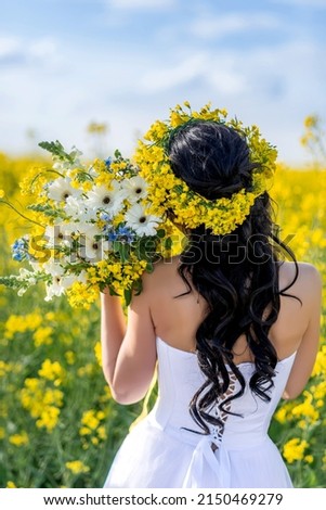 close-up of a wedding bouquet with yellow, white and blue flowers in the hands of the bride. Photo from the back