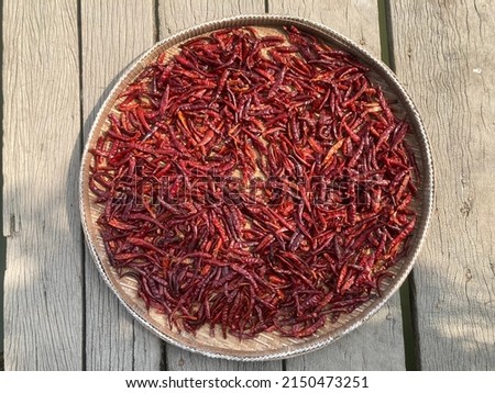 Picture of fresh peppers in Thailand that have been dried in the sun.  to cook  very spicy  Dried chili peppers in a basket, sunny outdoors, sunny, summer