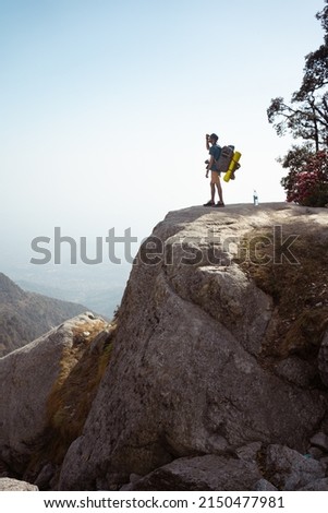 A Traveller Admiring the view at Triund, Indrahar Pass Trail, Dauladhar Range, Himachal Pradesh, India. Royalty-Free Stock Photo #2150477981