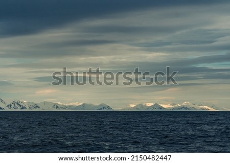 Panoramic view of Blue hour of the mountains, snow and Sea in Svalbard, Norway.