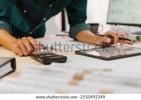 Close up Architect or Engineer pressing on calculator for calculating value estimating for safety with the drawing construction building. Royalty-Free Stock Photo #2150492349