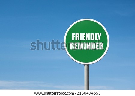 'Friendly reminder' sign in green round frame. Clear blue sky is on background Royalty-Free Stock Photo #2150494655