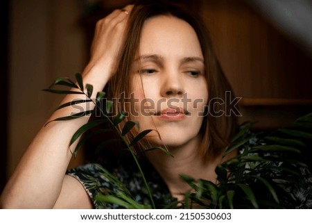 Woman relaxing at home in plants. an attractive woman of forty years of age. Home recovery, rest.