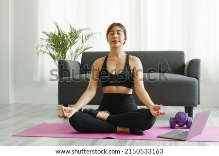 Attractive wellness Asian young woman sit on carpet breathing with yoga lotus pose, Yoga Exercise for Wellness Concept.