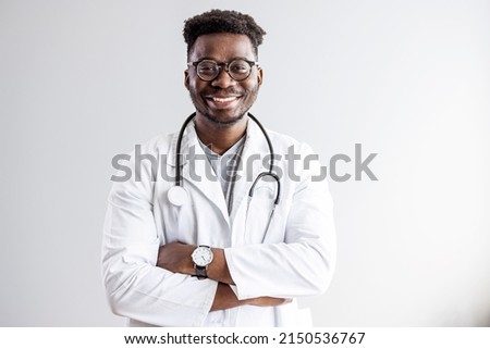 Portrait of happy african doctor at private clinic. Happy african american male nurse. Friendly african male therapist posing over gray background. Medical concept of young male doctor 