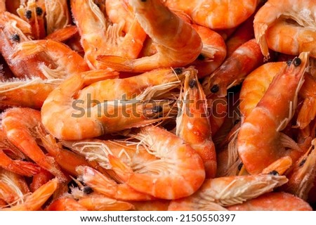 Frozen shrimp. Seafood on the counter. Fish market. Close-up shooting of seafood. Box with shrimp. Photo of shrimp in the supermarket. Wholesale of fish.  Peeled shrimp. Royalty-Free Stock Photo #2150550397