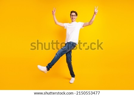 Full body profile side photo of young man good mood show fingers peace cool v-symbol isolated over yellow color background