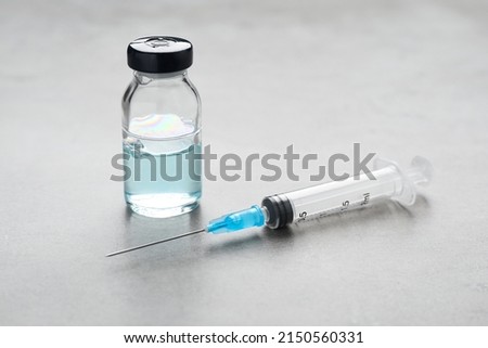 Syringe and vial on grey table. Medical anesthesia Royalty-Free Stock Photo #2150560331