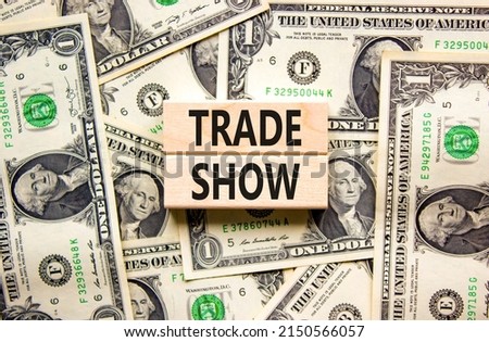 Trade show symbol. Wooden blocks with concept words Trade show on beautiful background from dollar bills. Business economic financial trade show concept. Copy space.