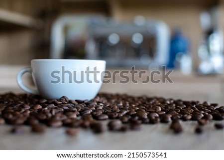 Blurred image of coffee cup among coffee beans Coffee shop interior and dark mood pictures