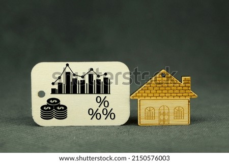 Wooden houses and wooden tags with volatility graphs, money and percent concept