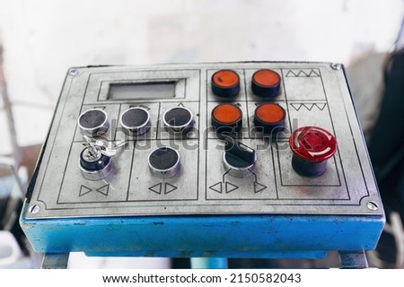 Key switch and control buttons of industrial machinery, close up.
