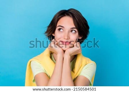 Photo of adorable sweet woman wear green t-shirt arms cheeks looking empty space isolated blue color background