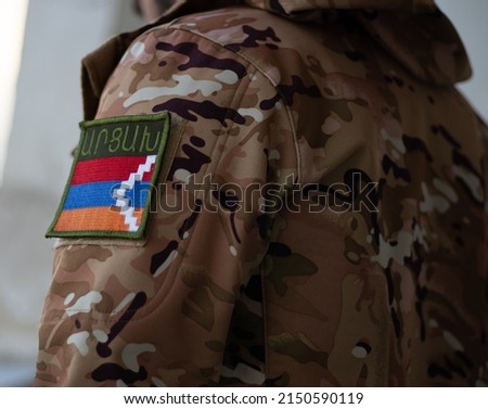 Artsakh Soldier. Soldier with flag Artsakh. Artsakh flag on a military uniform. Camouflage clothing