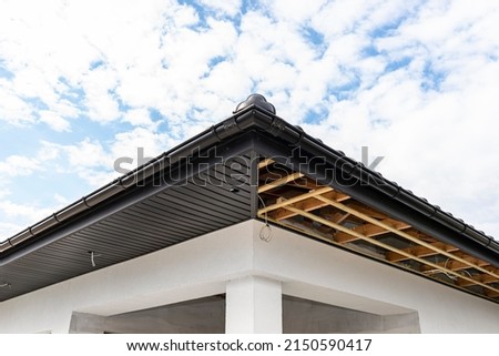 Scaffolding with three rows of wooden battens and a modern graphite soffit made in half, visible H and J slats. Royalty-Free Stock Photo #2150590417