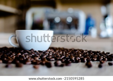 Blurred image of coffee cup among coffee beans Coffee shop interior and dark mood pictures