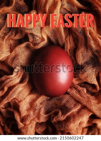 Painted easter egg on orange air gauze with inscription Happy Easter. Easter concept. Easter greeting card.