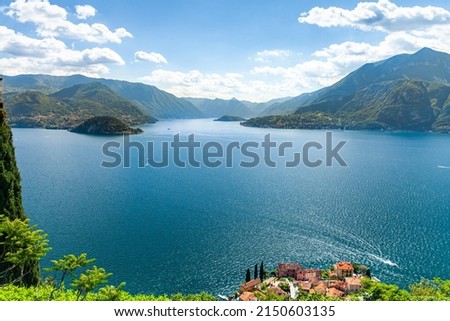 Panoramic aerial view of Lake Como from Varenna towards Bellagio with clear sky in summer and boats on the water. The houses of Varenna and Lake Como.