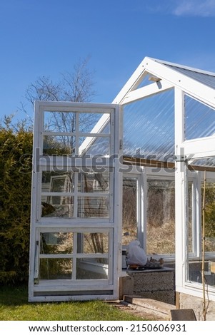 Greenhouse with open door in early spring. No people or plants growing