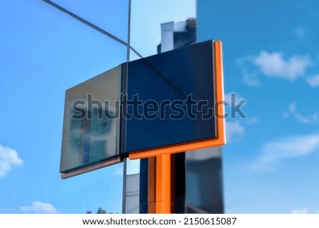 Modern company sign on a glass building. Blank for logo, brand presentation