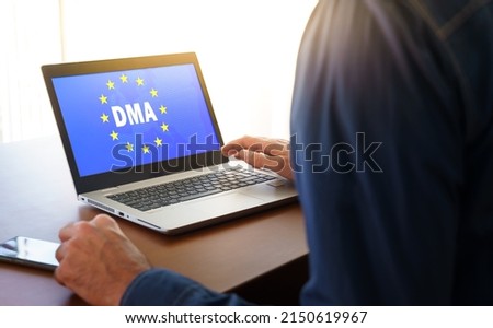 DMA and the flag of the european union displayed on a modern laptop.DMA or Digital Markets Act concept. Royalty-Free Stock Photo #2150619967