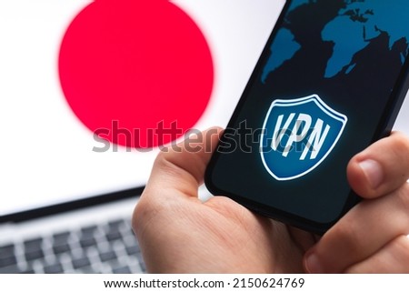 VPN in Japan. Secure and safe internet concept. Privacy. Hand with mobile phone and VPN application. Flag and laptop on the background photo