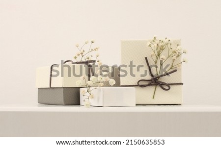 Craft gift boxes with flower on light beige wall copy space background. Minimalism style template background. Royalty-Free Stock Photo #2150635853